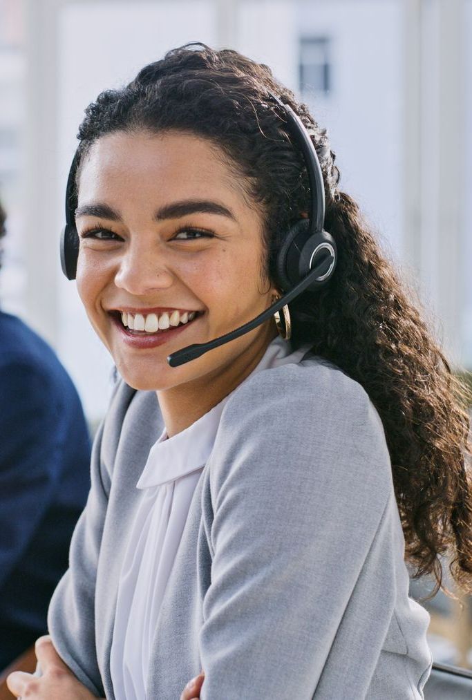 A woman wearing a headset is smiling and looking at the camera - The Woodlands, TX - Premiere Services