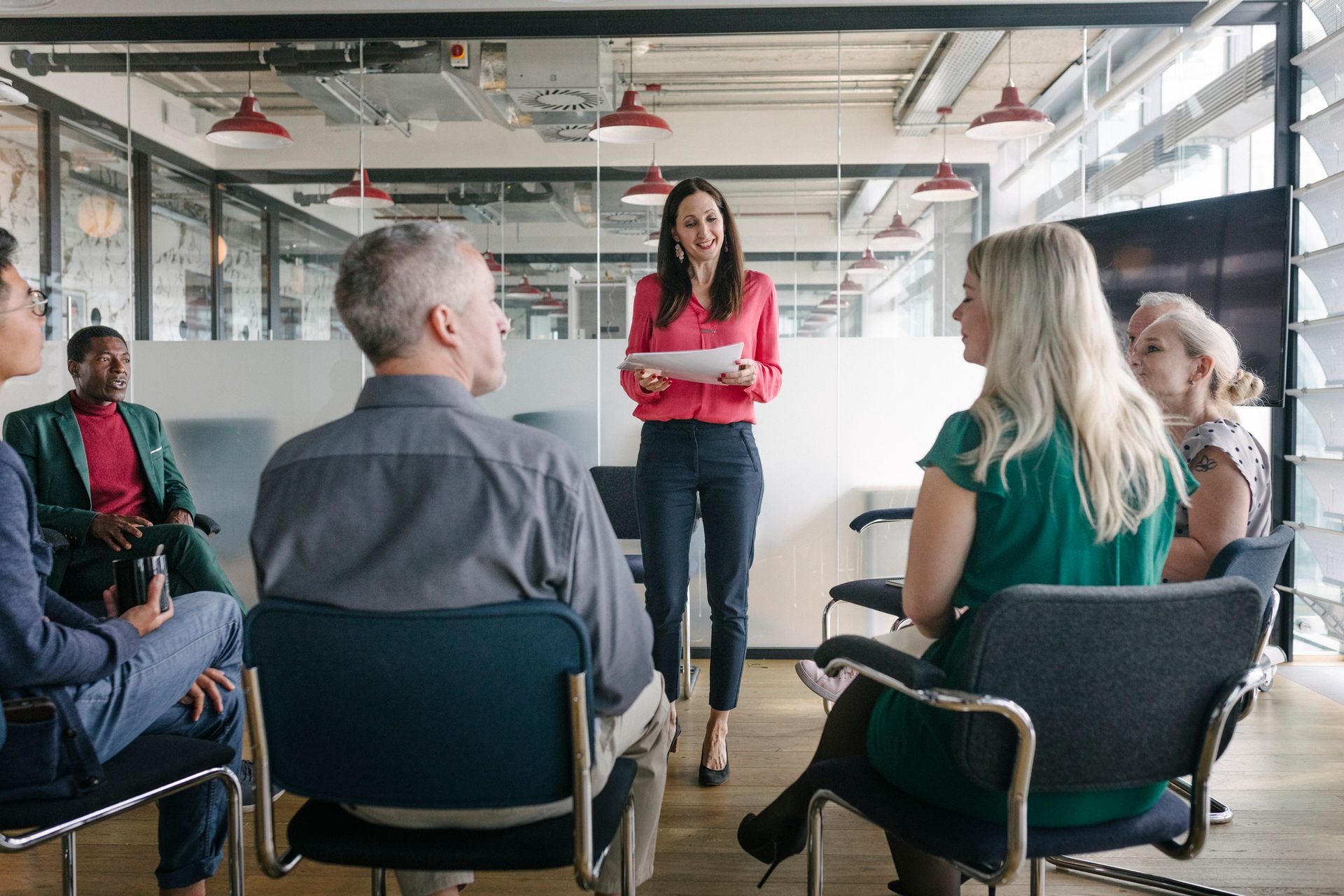 A woman is giving a presentation to a group of people sitting in chairs - The Woodlands, TX - Premiere Services
