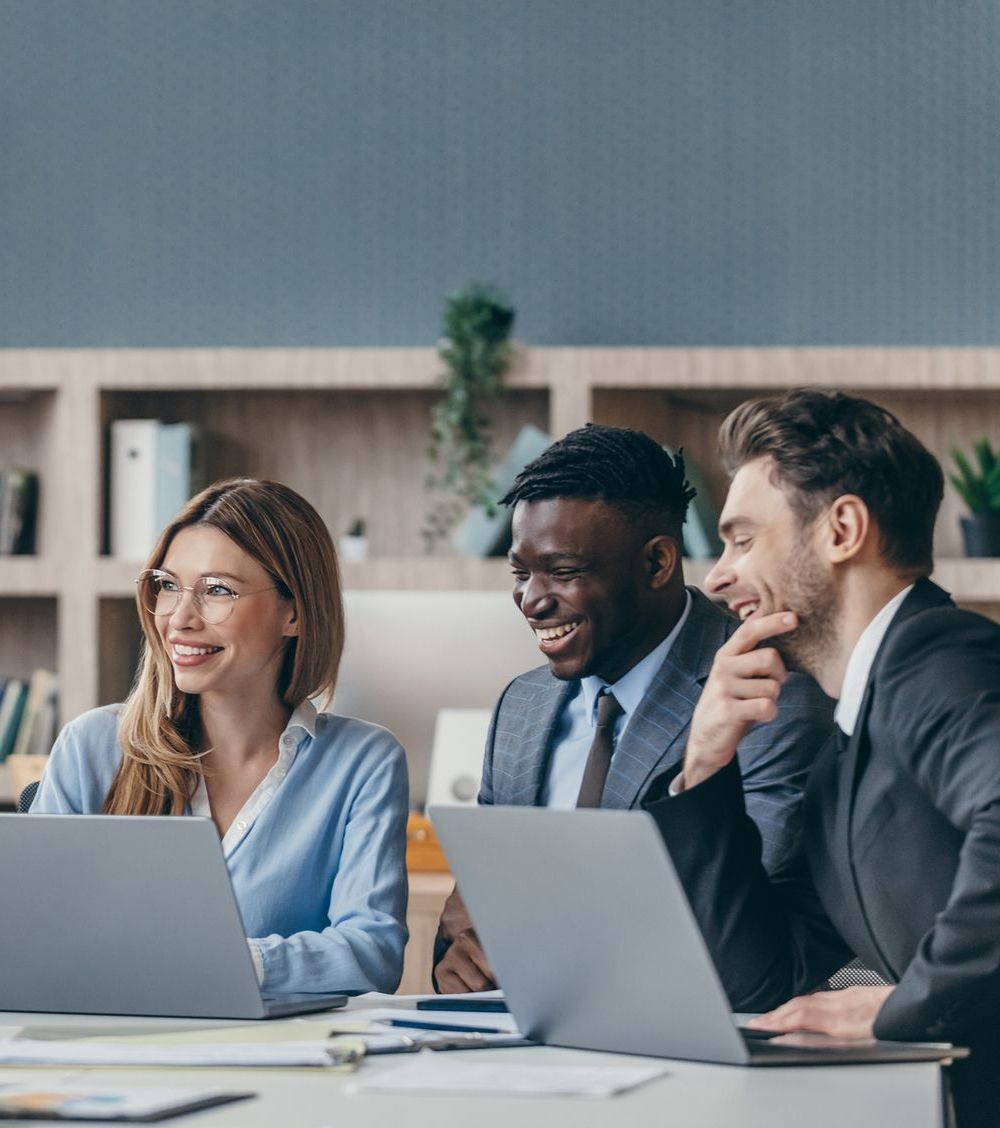 A group of people are sitting at a table with laptops - The Woodlands, TX - Premiere Services