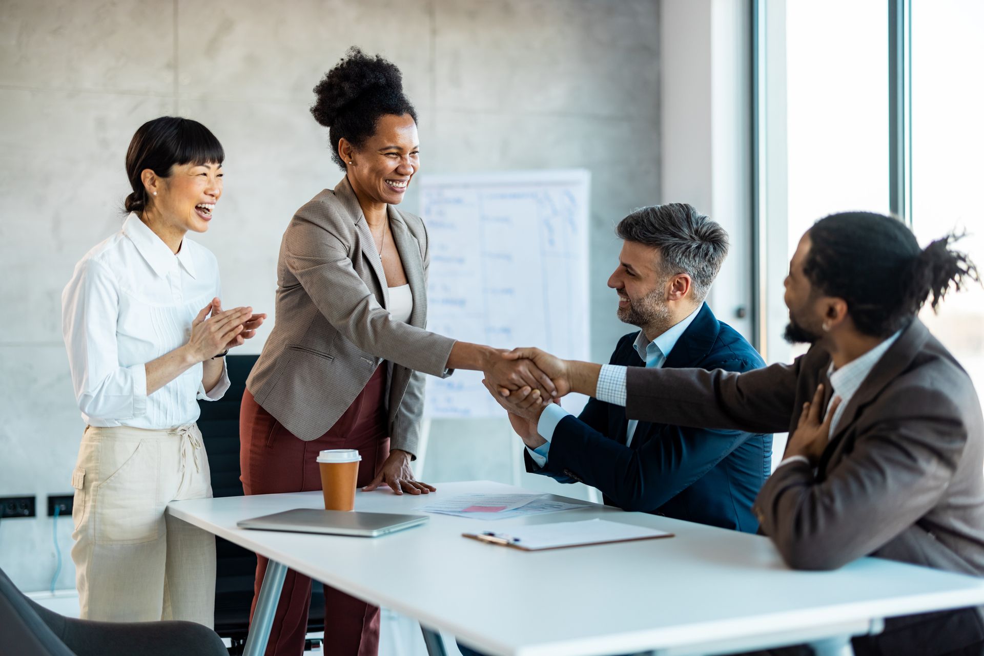 A group of business people are shaking hands in an office - The Woodlands, TX - Premiere Services