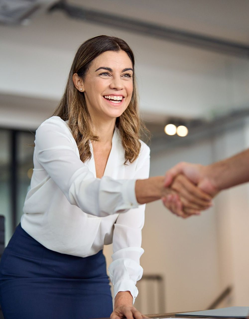 A woman is shaking hands with a man in an office - The Woodlands, TX - Premiere Services