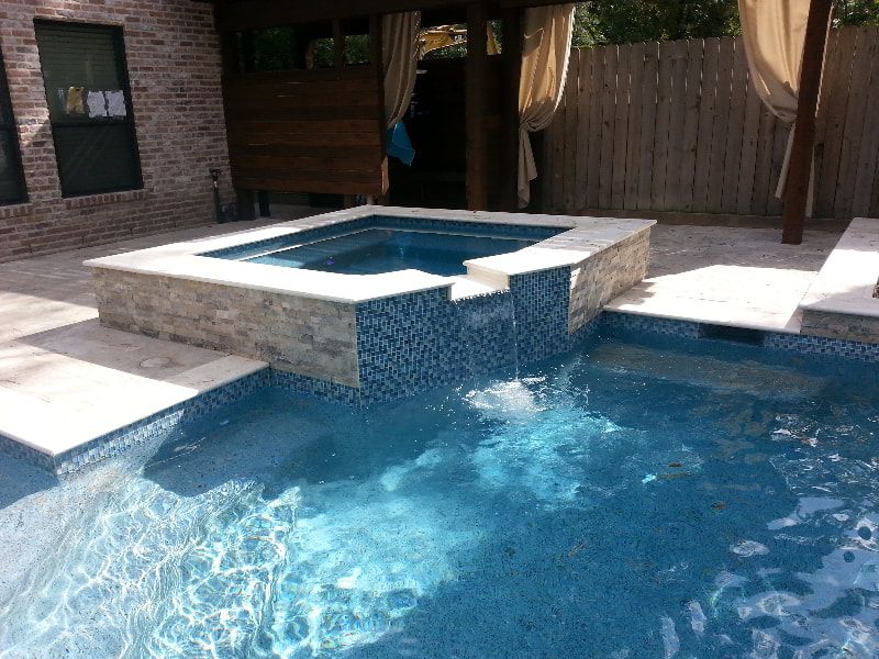 A large swimming pool with a hot tub in the middle