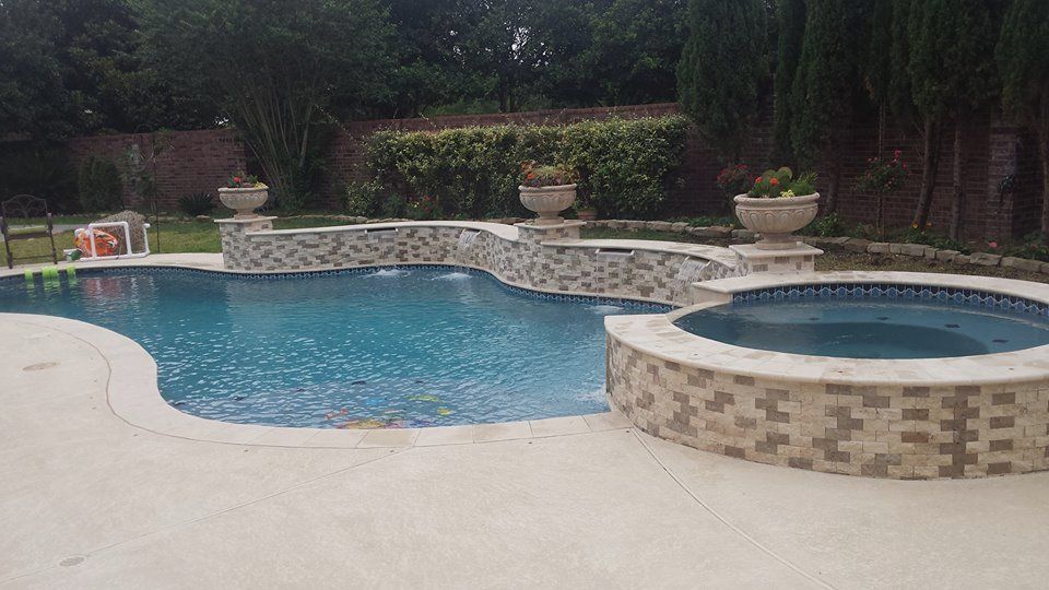 A large swimming pool with a hot tub in the backyard.
