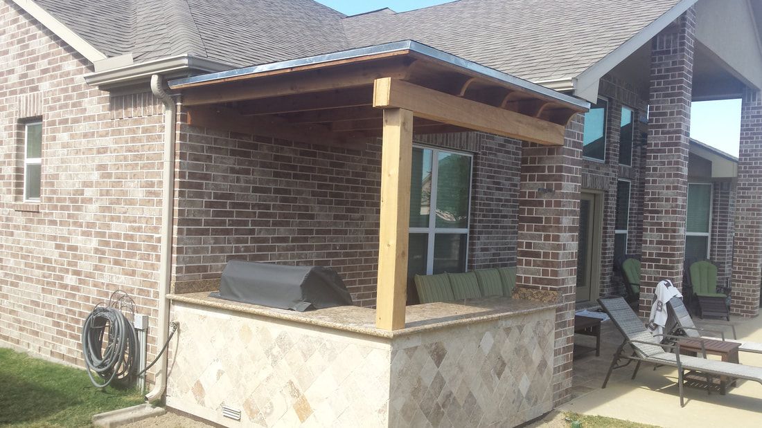 A brick house with a wooden porch and a grill.