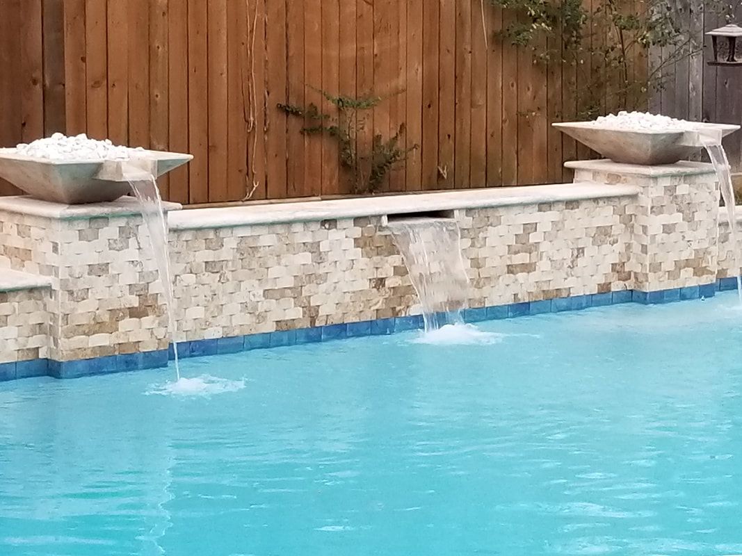 There is a waterfall in the middle of the pool.