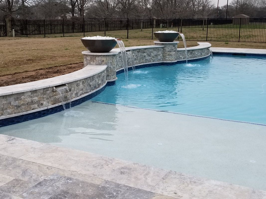 A large swimming pool with a waterfall in the middle of it.
