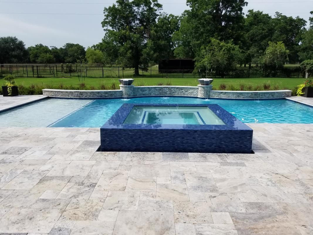 A large swimming pool with a hot tub in the middle