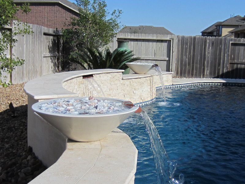A swimming pool with a fountain in the middle of it