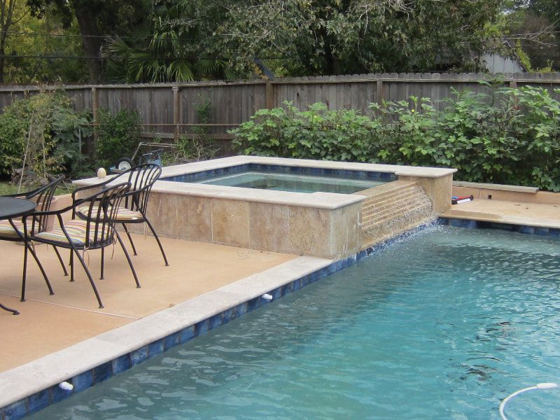 A swimming pool with a table and chairs next to it