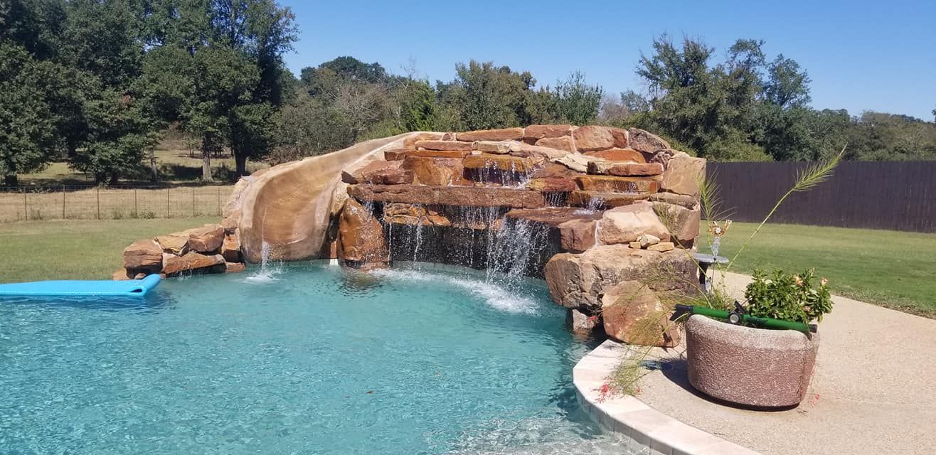 There is a waterfall in the middle of the pool.