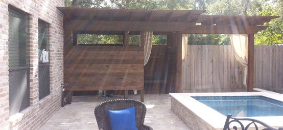 A patio with a pergola and a pool in the backyard.