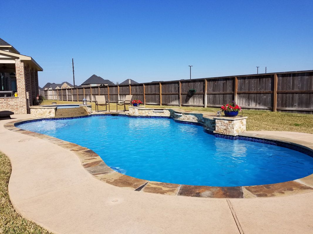 There is a large swimming pool in the backyard of a house.