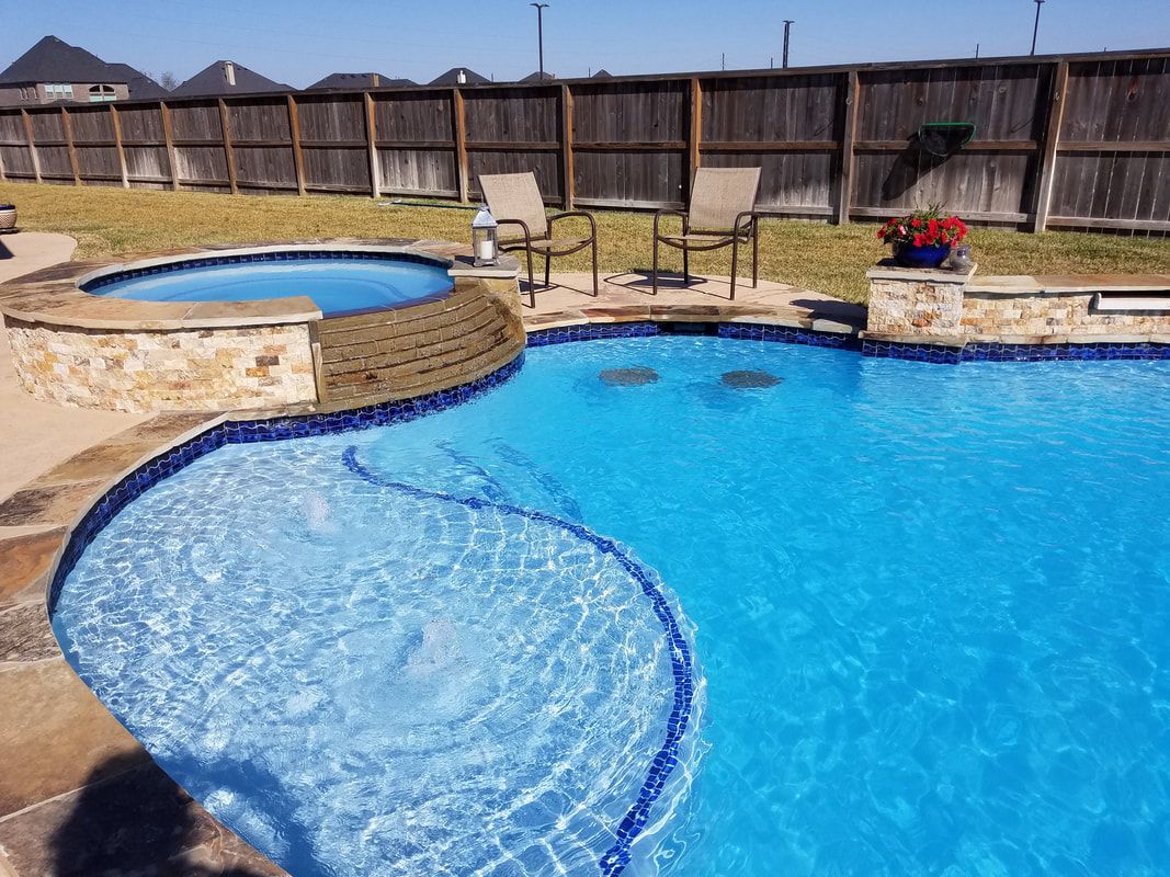 A large swimming pool with a hot tub in the backyard.