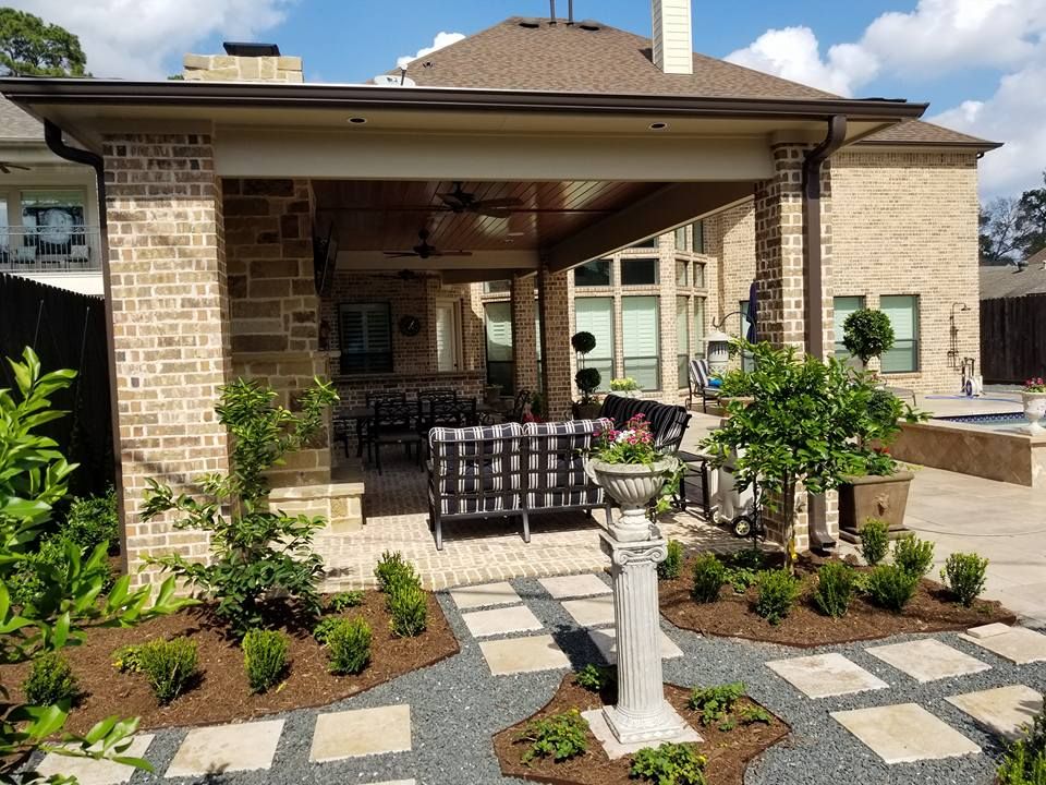 A brick house with a covered patio and a couch