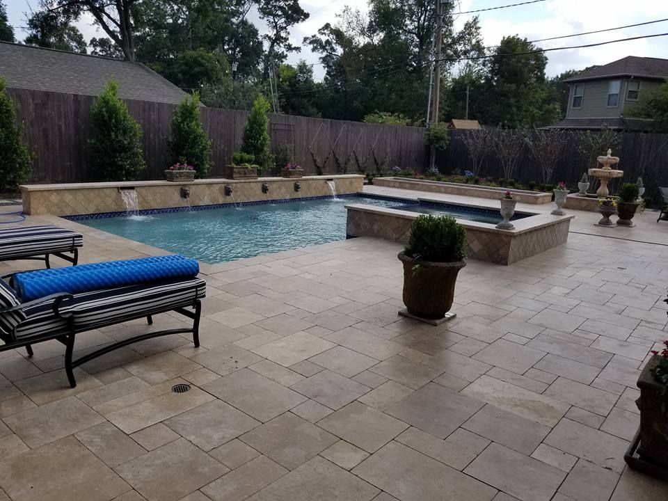 A patio with a large swimming pool and chairs
