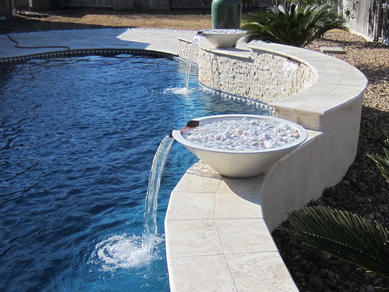 A swimming pool with a waterfall in the middle of it