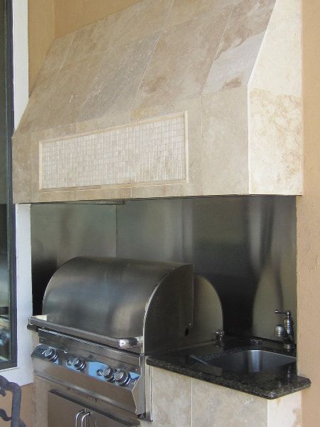 A stainless steel grill with a hood above it