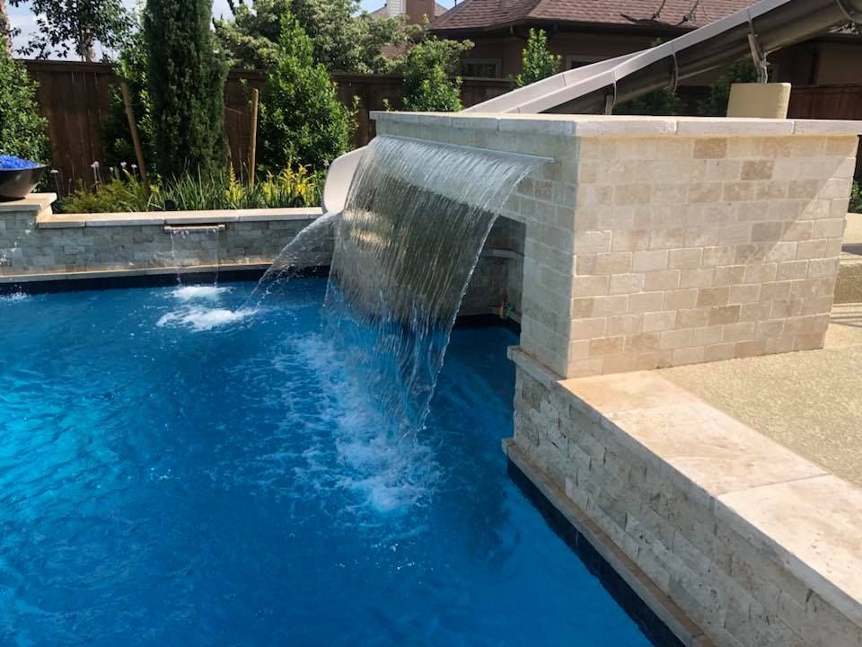 There is a waterfall in the middle of the pool.