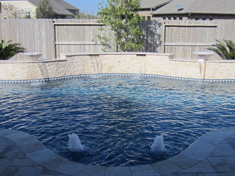 A swimming pool with a fountain in the middle of it