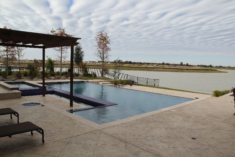A large swimming pool with a lake in the background