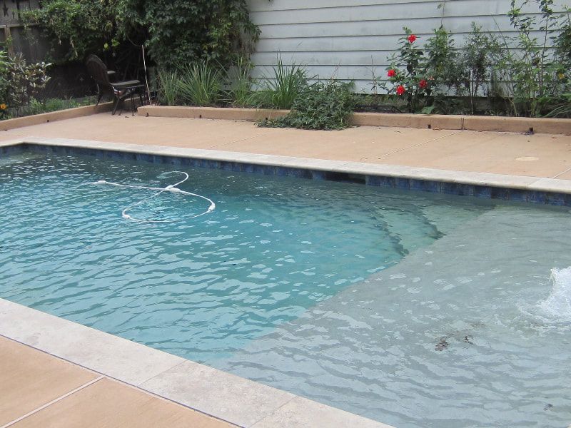 A large swimming pool with a fountain in the middle