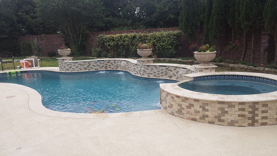 A large swimming pool with a hot tub in the backyard.