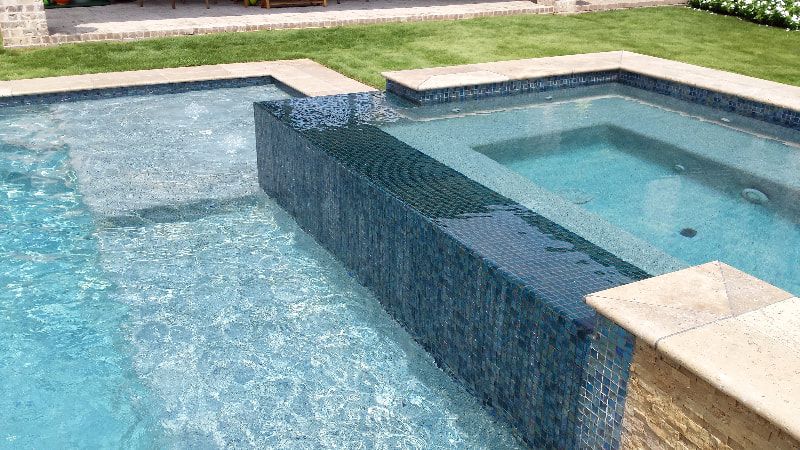 A large swimming pool with a hot tub in the middle of it.