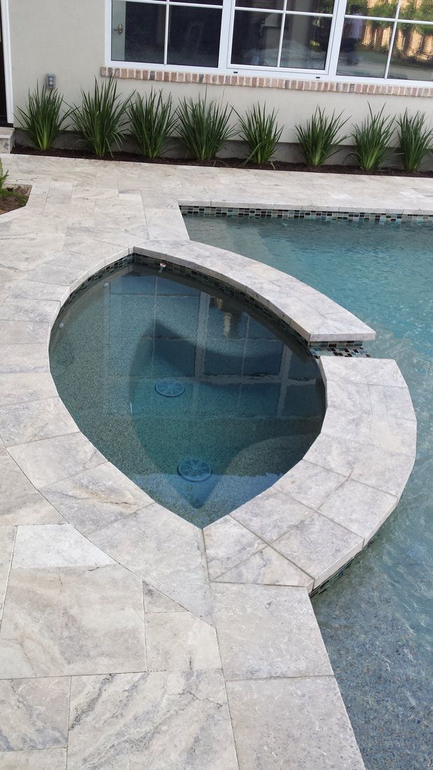 A swimming pool with a heart shaped hot tub in the middle of it.