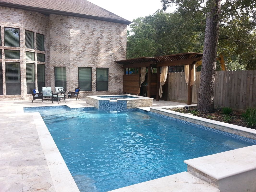A large swimming pool is in the backyard of a house.
