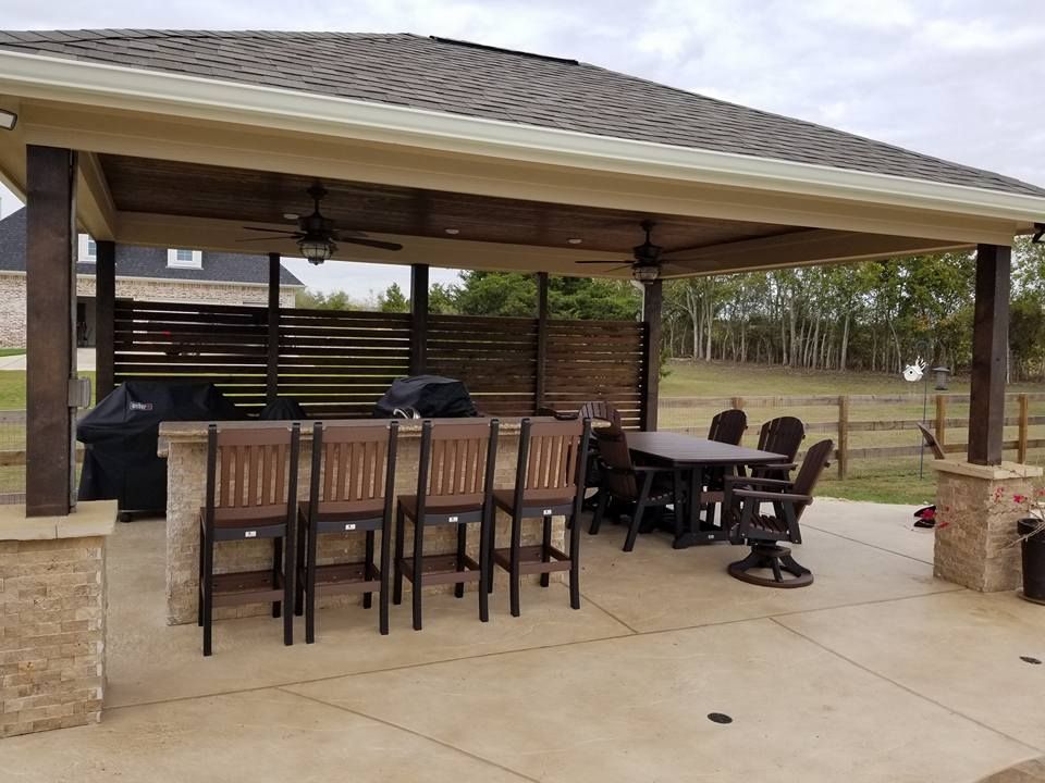 A patio with a table and chairs under a pavilion.