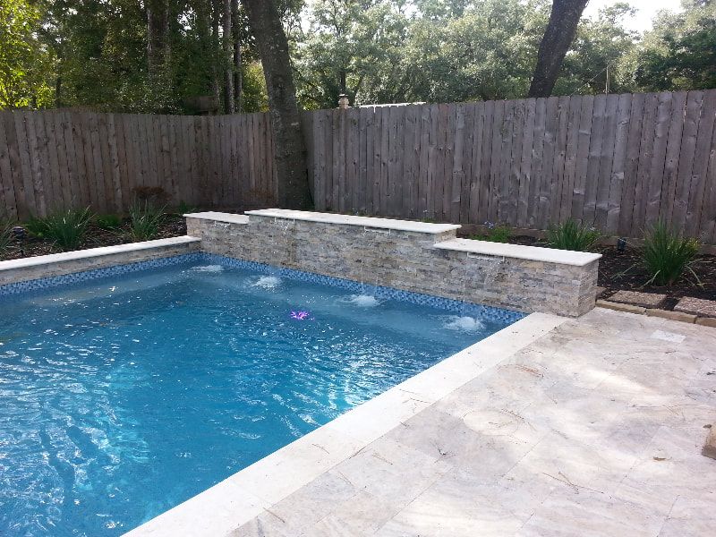 A large swimming pool with a wooden fence in the background
