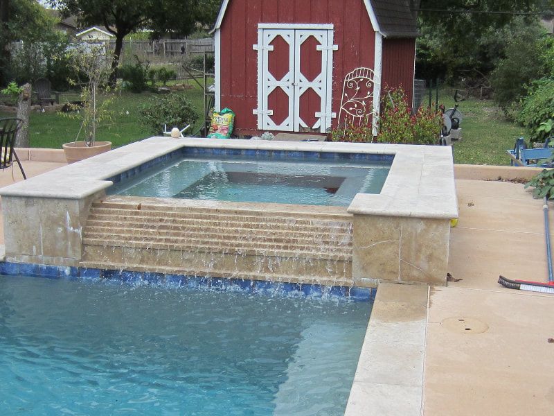 A swimming pool with a red barn in the background