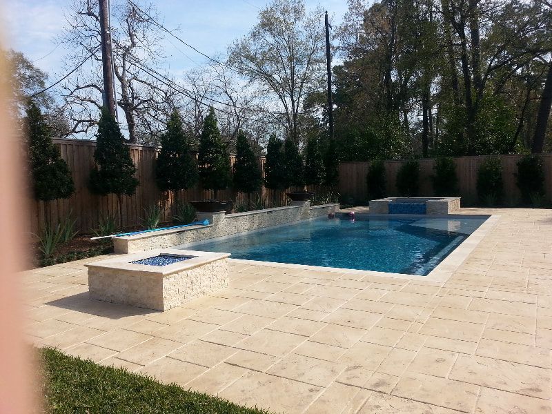 A large swimming pool in a backyard with trees in the background