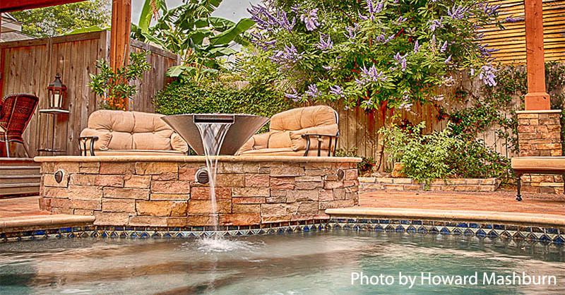 There is a waterfall in the middle of the pool.