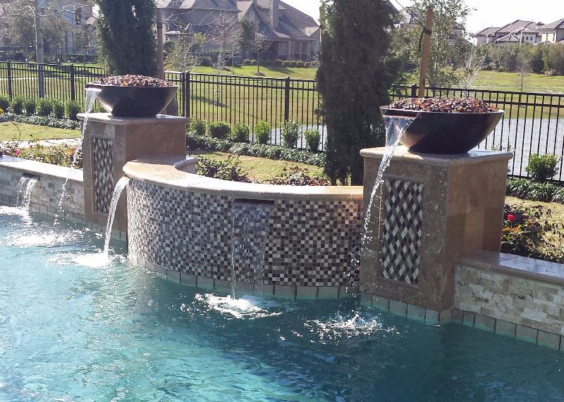 A swimming pool with a fountain in the middle of it