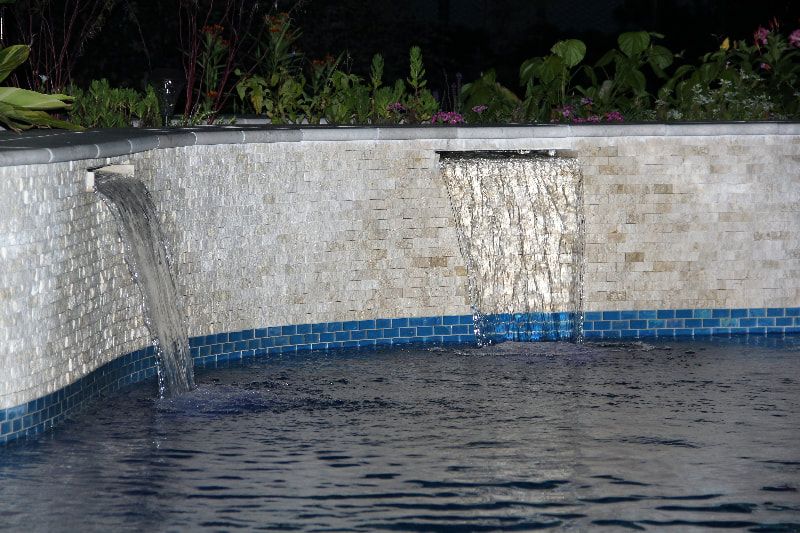 A waterfall is in the middle of a swimming pool