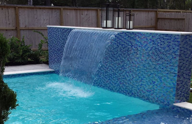 There is a waterfall in the middle of the pool.