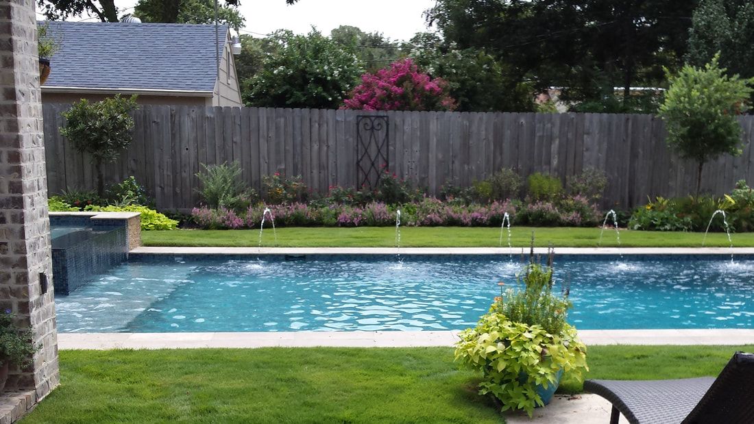 There is a large swimming pool in the backyard of a house.