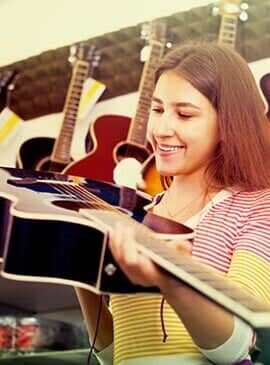 Girl smiling while buying a guitar — Pawnshop in Pawn in New Port Richey, FL