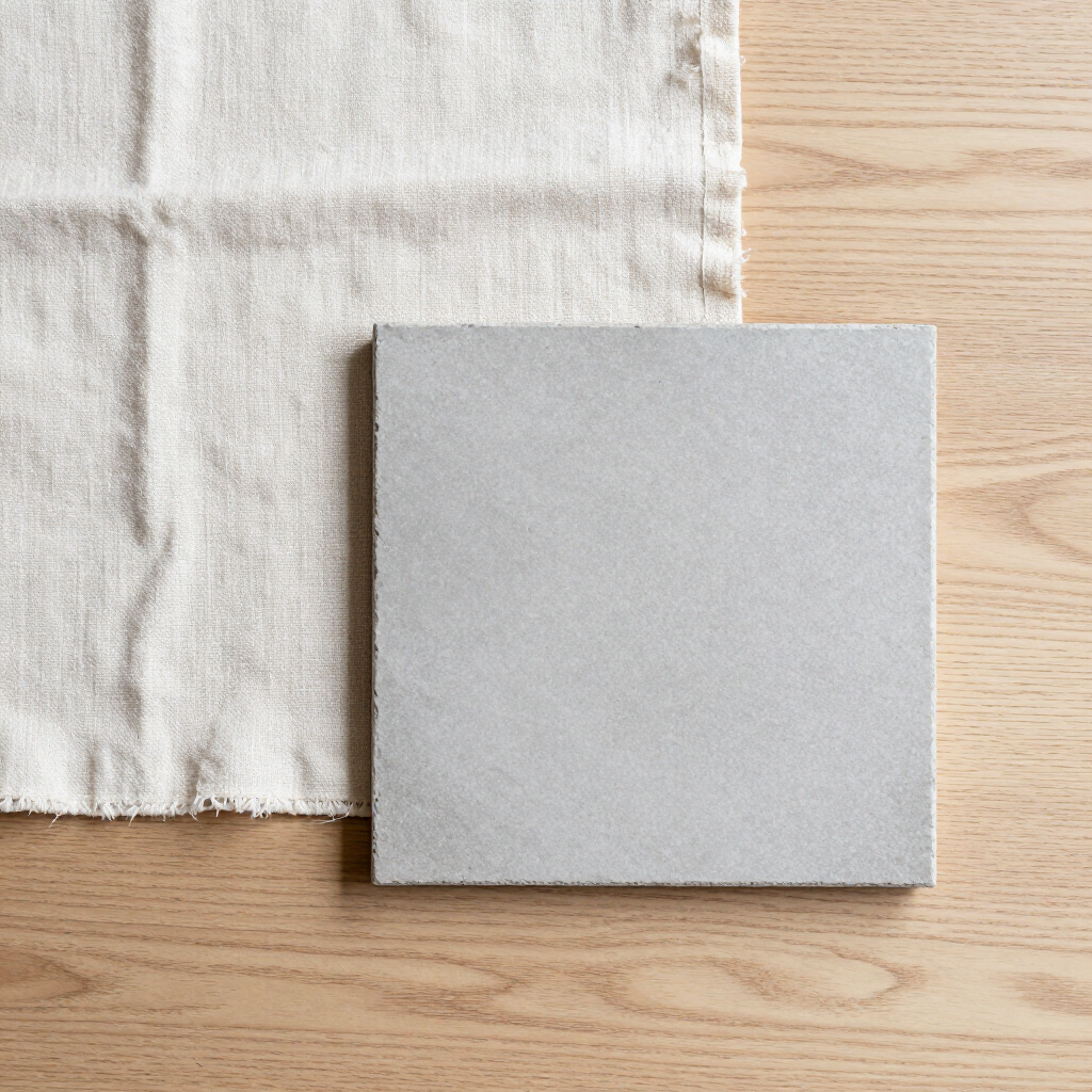Flat-lay of light oak grain, undyed linen swatch, and matte grey stone fragment