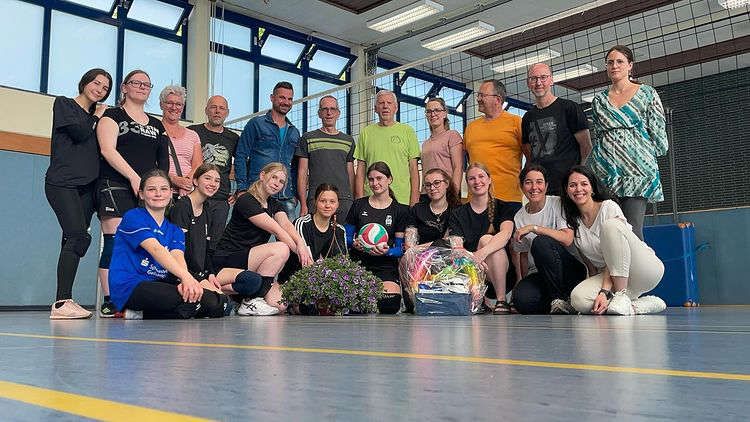 Volleyball-Abteilung in einer Turnhalle, Gruppenfoto mit einem Volleyball und Geschenken für Elmar