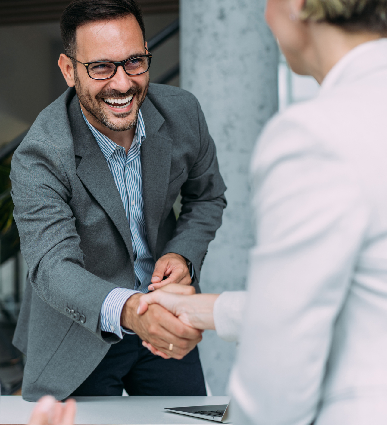 A man in a suit is shaking hands with a woman