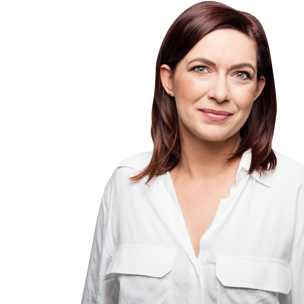 A woman with brown hair is wearing a white shirt and smiling