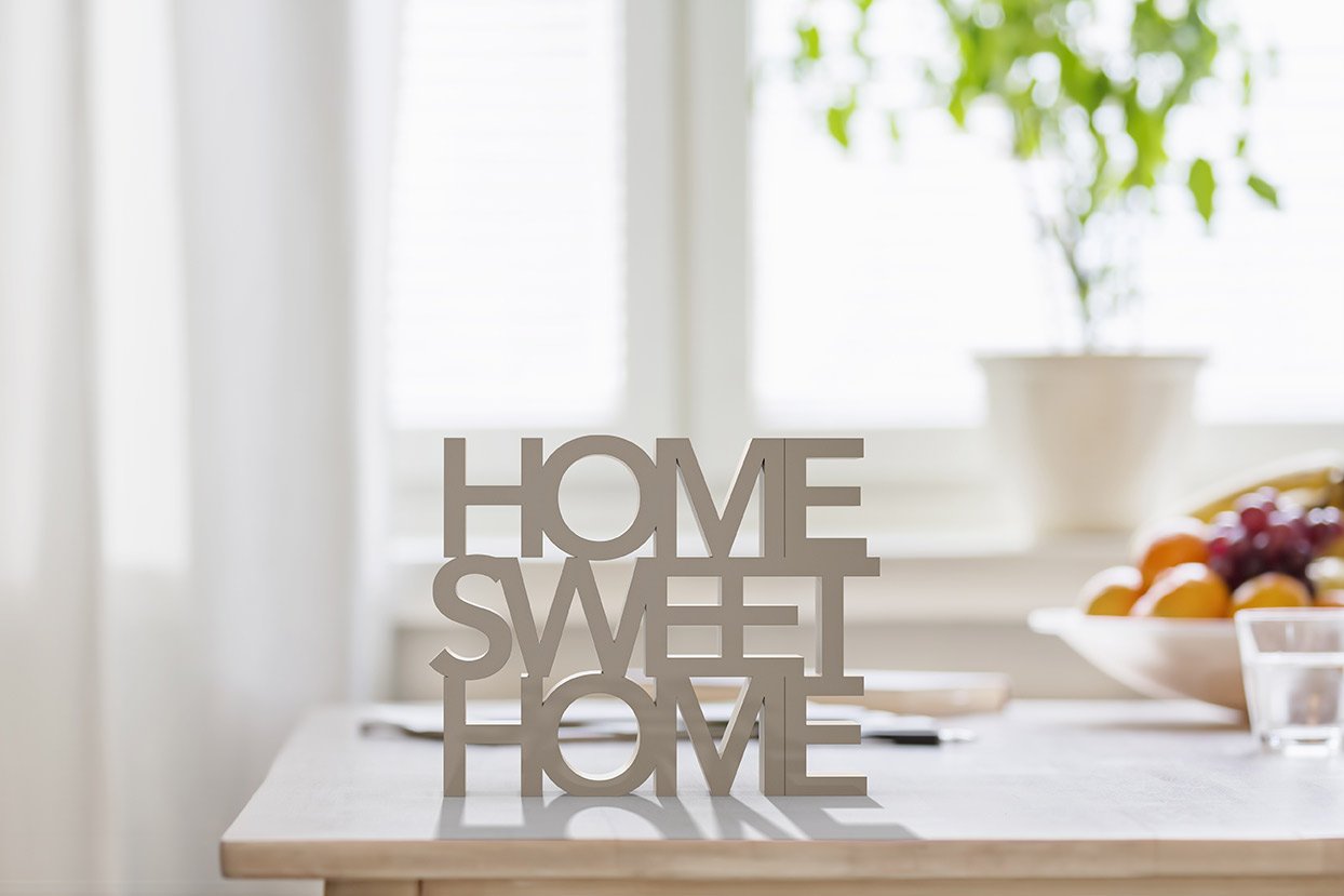 A wooden sign that says `` home sweet home '' is sitting on a table.