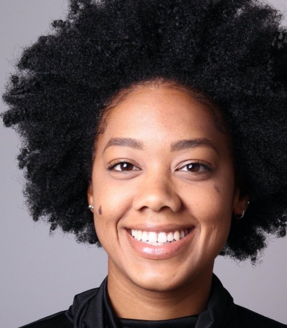 a woman with an afro is smiling for the camera