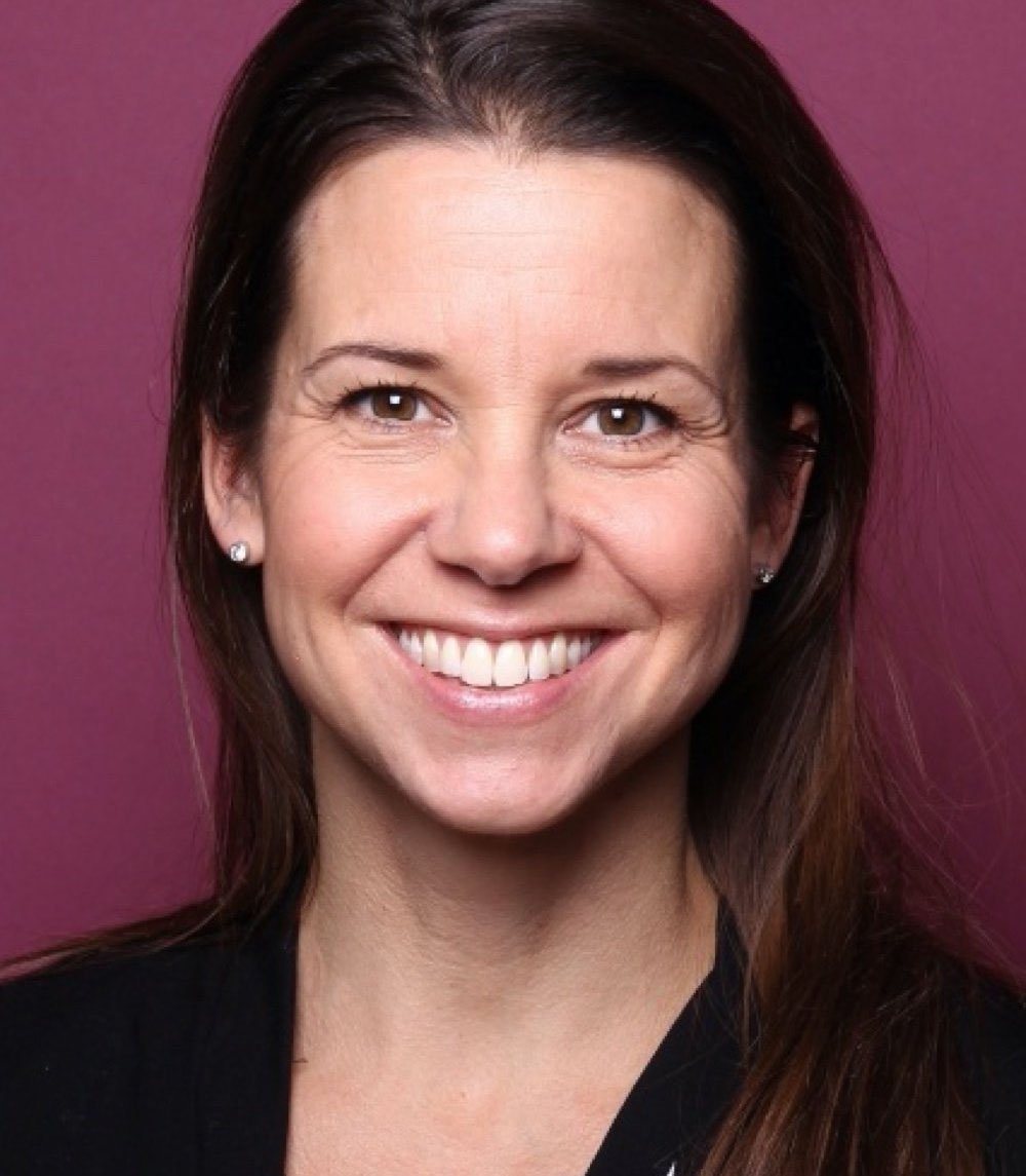 a woman is smiling and wearing a black shirt