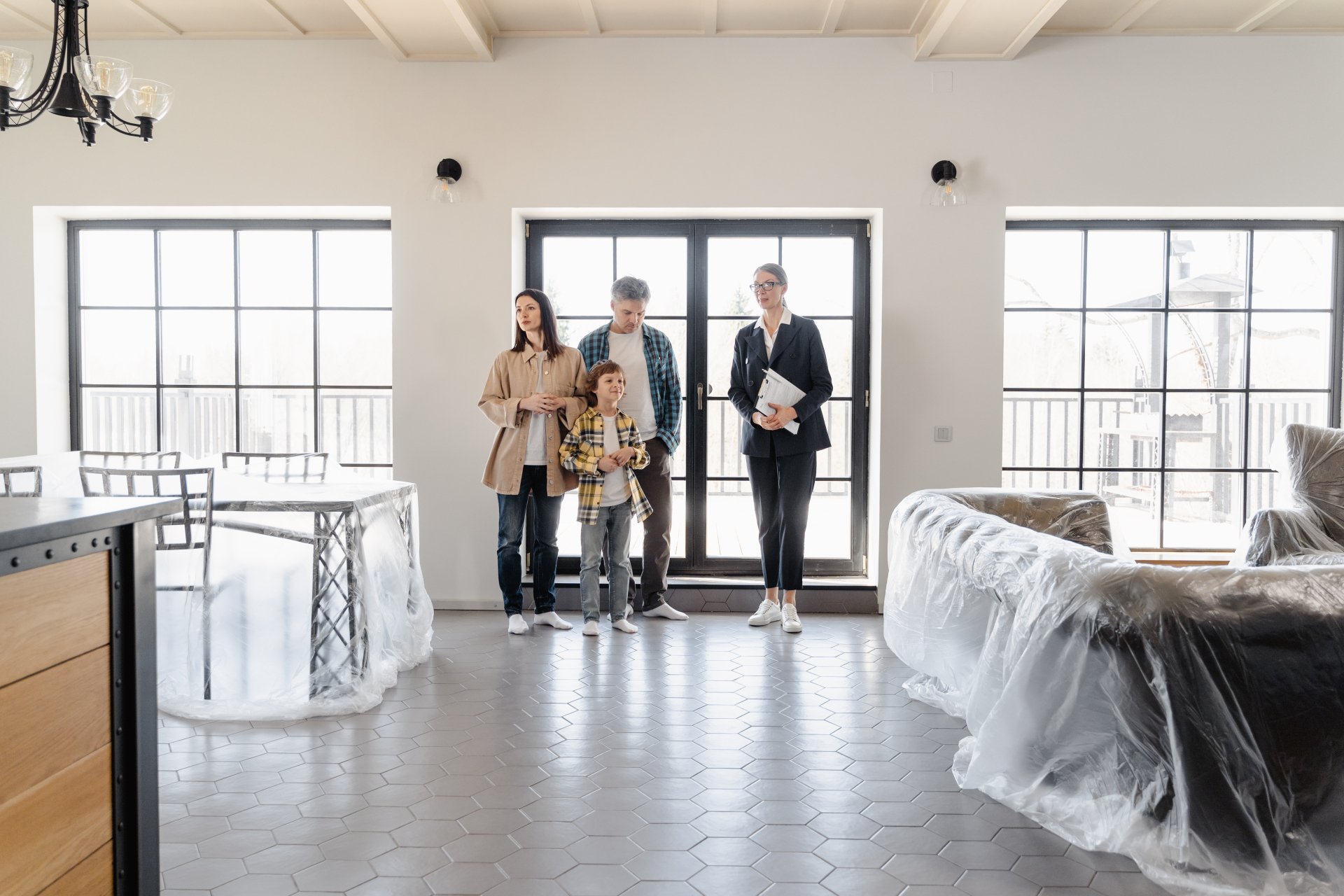 A family is standing in a living room in a new house.